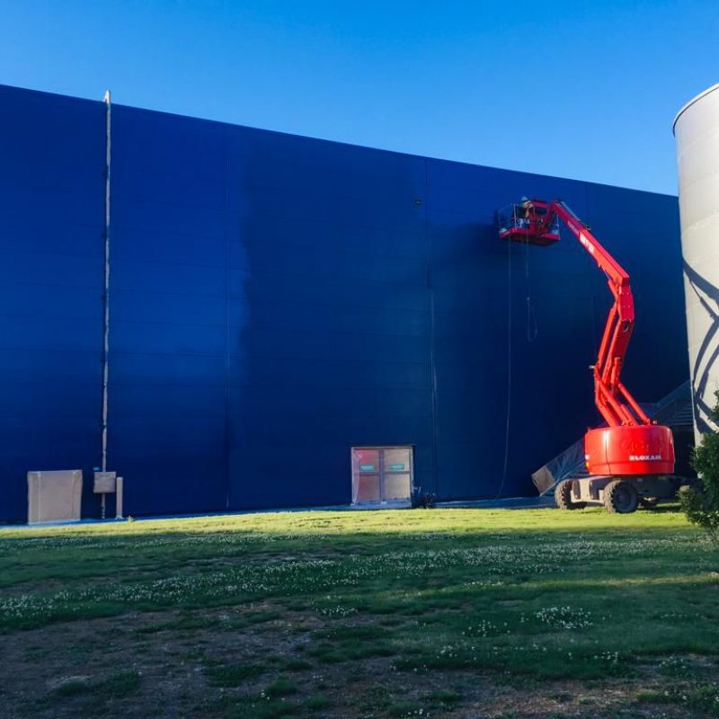 Photo d'intervention pour la remise en peinture des 8000m² de façade par procédé électrostatique